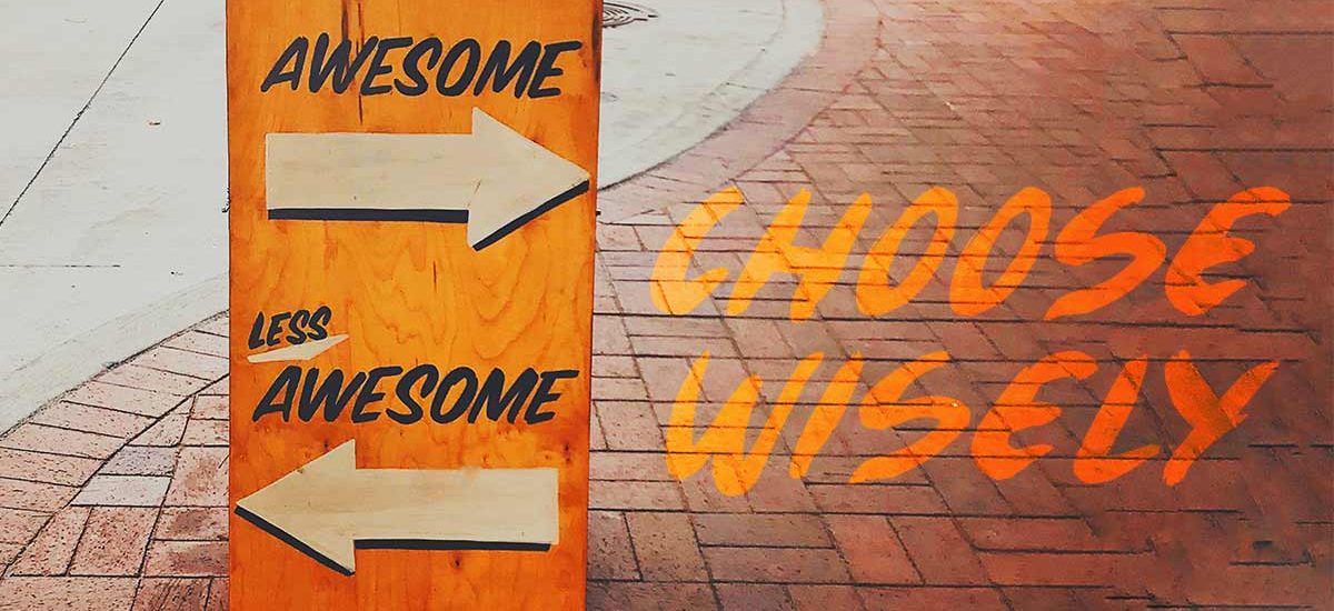 sign on brick sidewalk that reads awesome and not awesome with arrows pointing in opposite directions with the words choose wisely